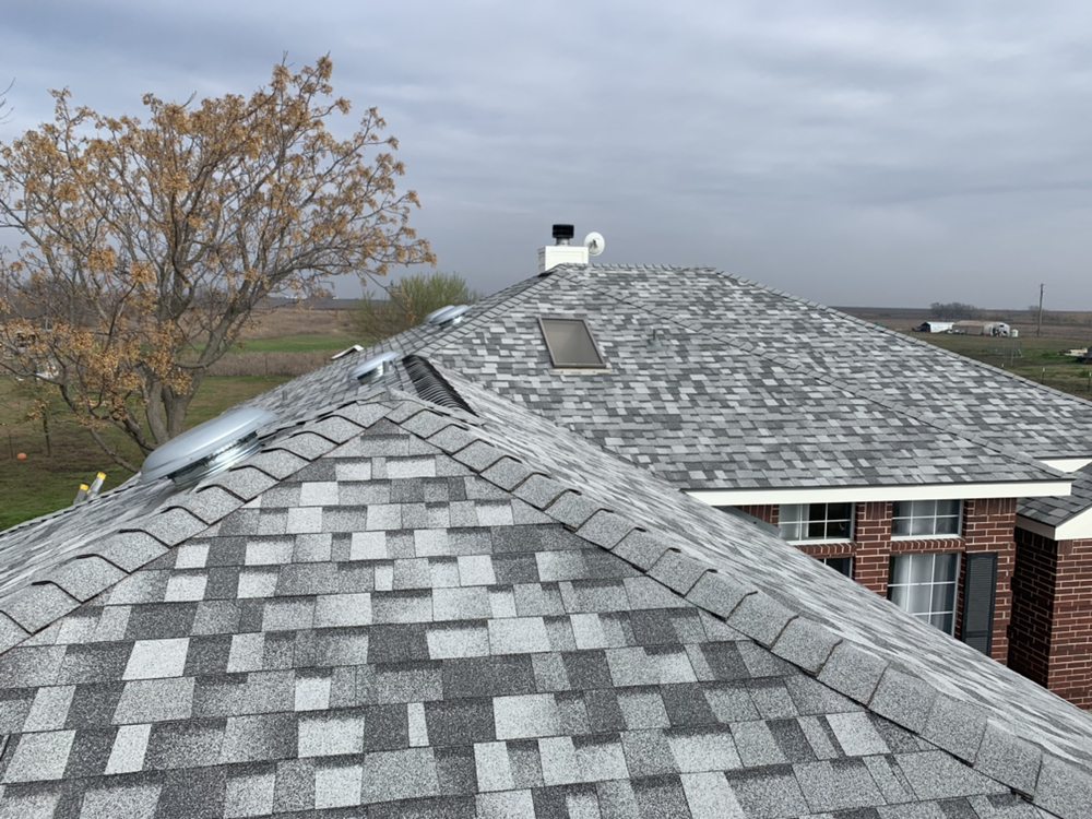 Roof replacement example: Completed light gray shingle roof replacement with skylights by FRS roofing company